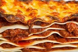 COOKING FOOD AND WINE. A picture of a piece of lasagna.